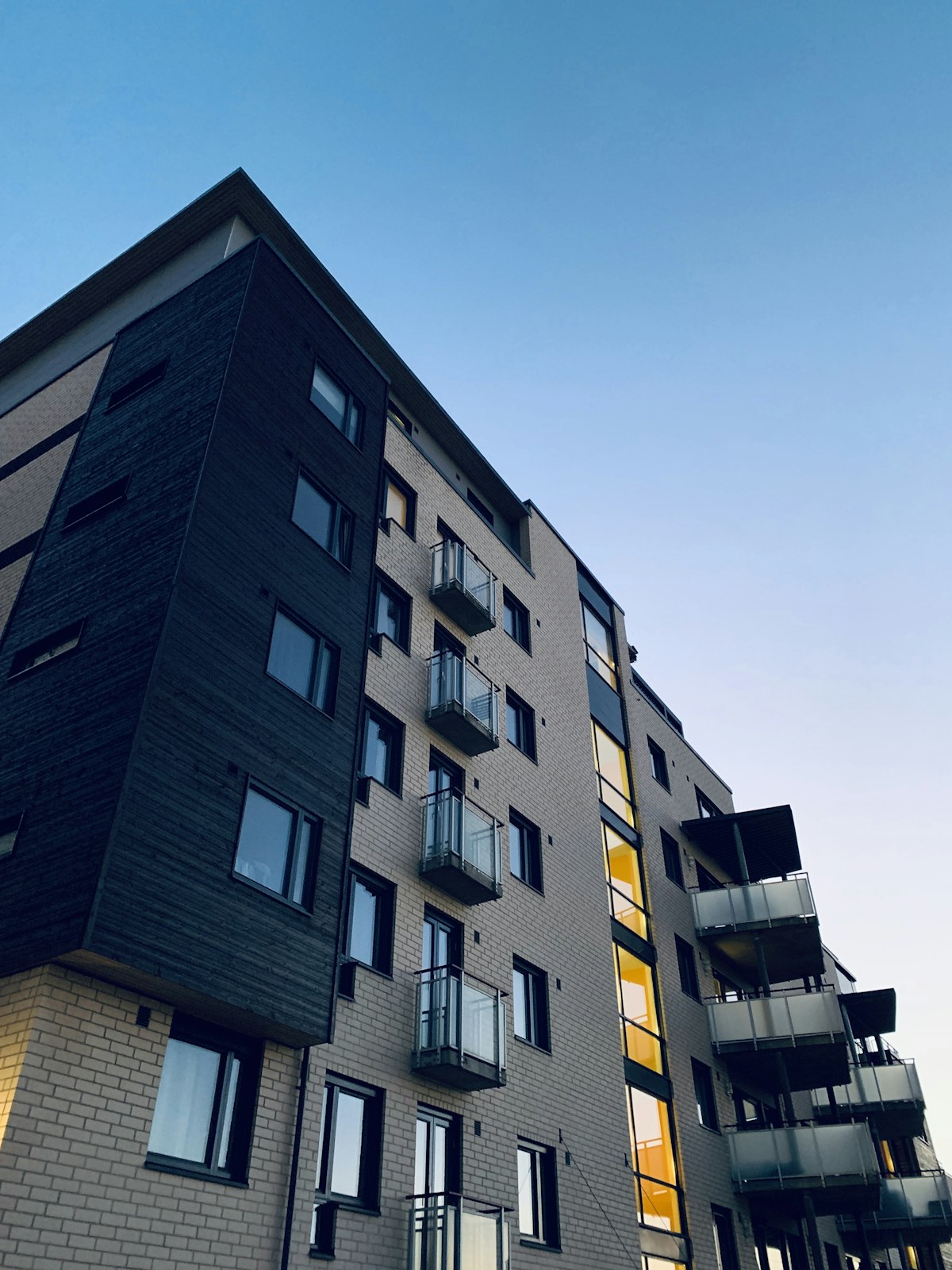 Facade of a modern housing complex with floor-to-ceiling windows.