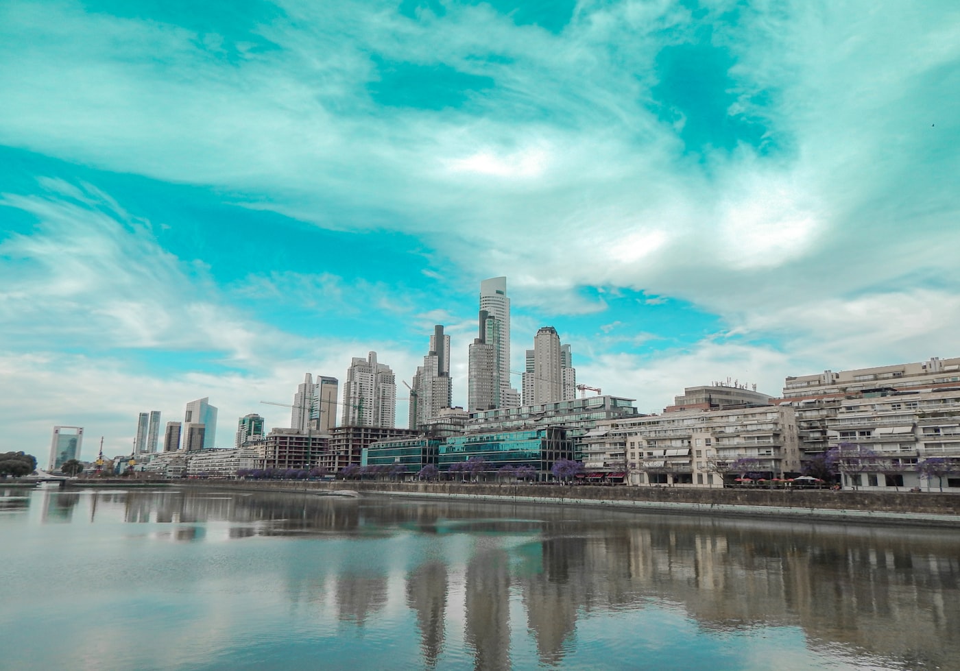 High-rise buildings next to an urban waterway at dusk.